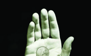 Man holding one cent coin on open palm, close-up of hand, (B&W)