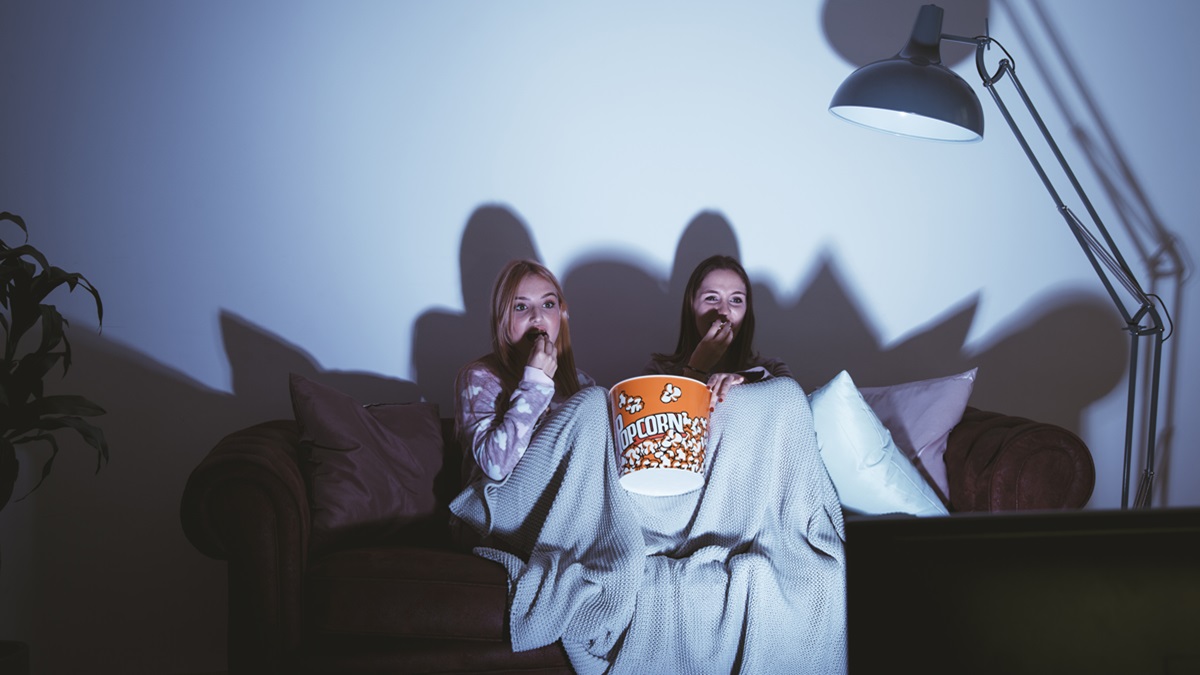 Unas chicas viendo una película de terror en el sofá