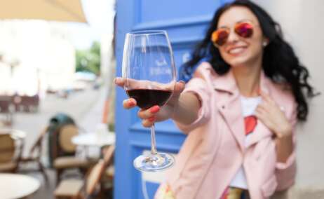 Una chica sostiene una copa de vino tinto