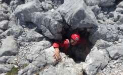 Una persona en una de las entradas de la Torca del Cerro del Cuevón