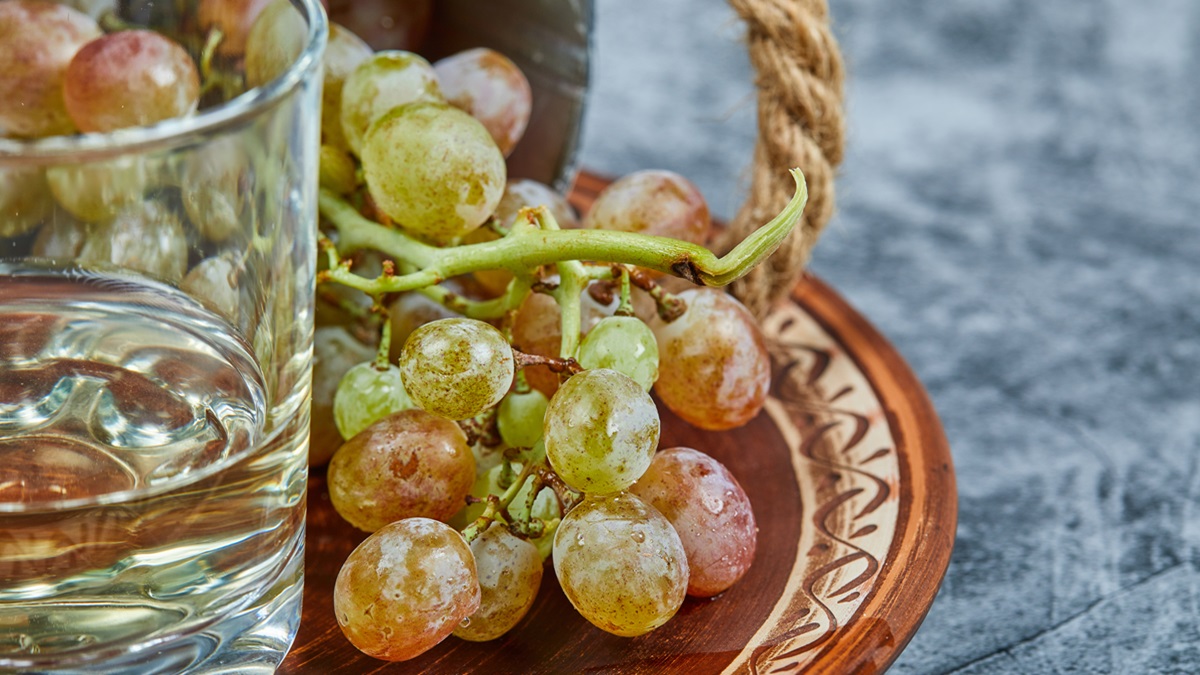 Una copa de vino blanco junto a unas uvas