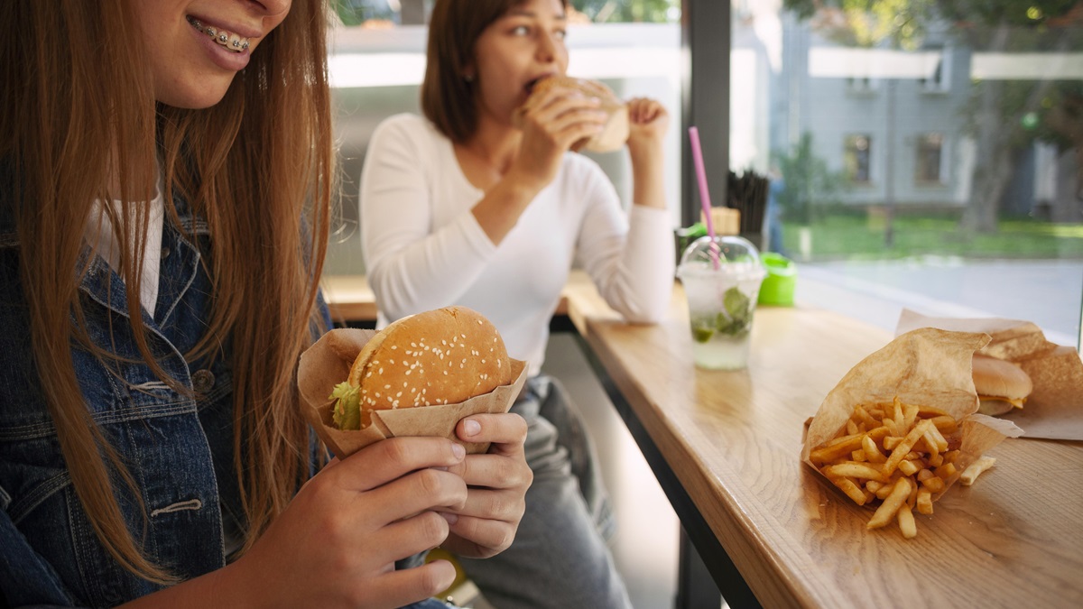 Unas amigas comen unas hamburguesas