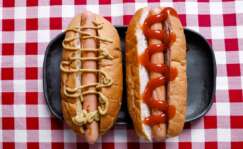 Dos perritos calientes con diferentes salsas