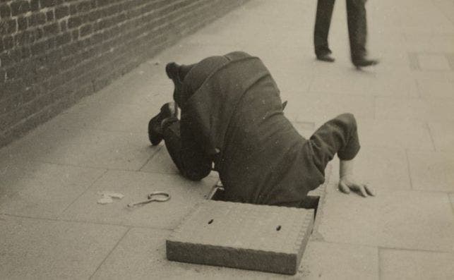 maar man looking inside a sidewalk inspection door 002