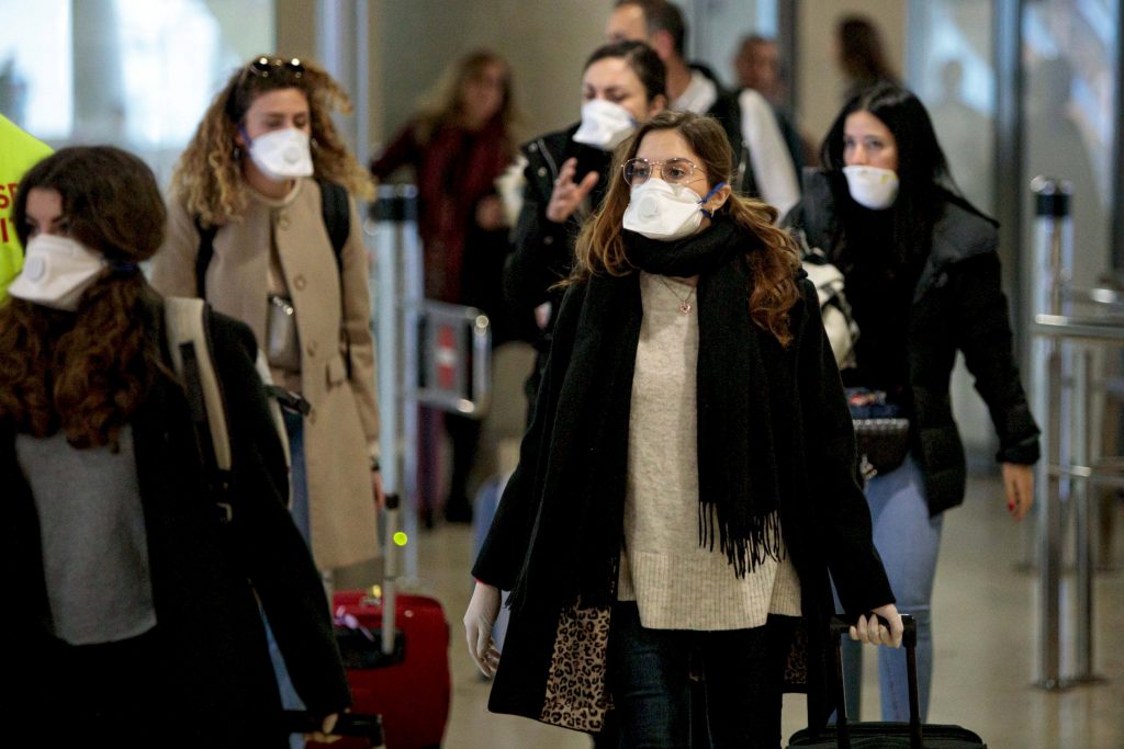 Viajeros protegidos con mascarillas por el coronavirus