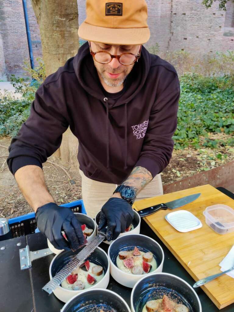 Chef preparando un plato en el tour gastronómico de Toulouse