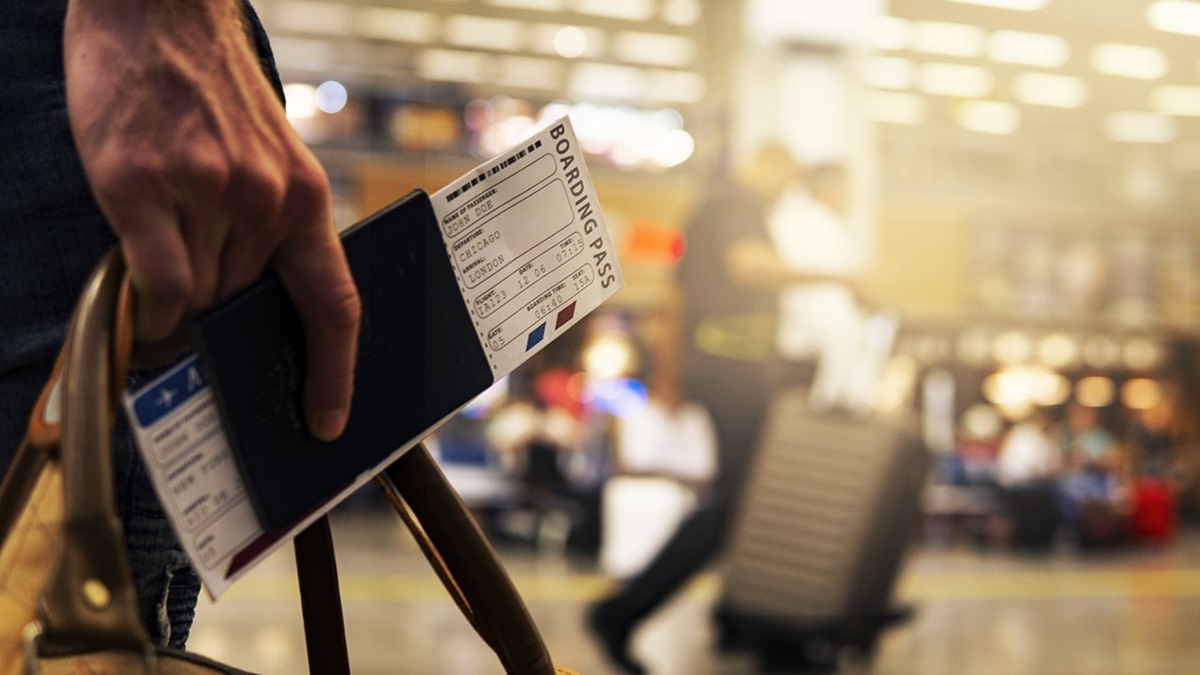 Una persona con pasaporte en mano y billetes de avión