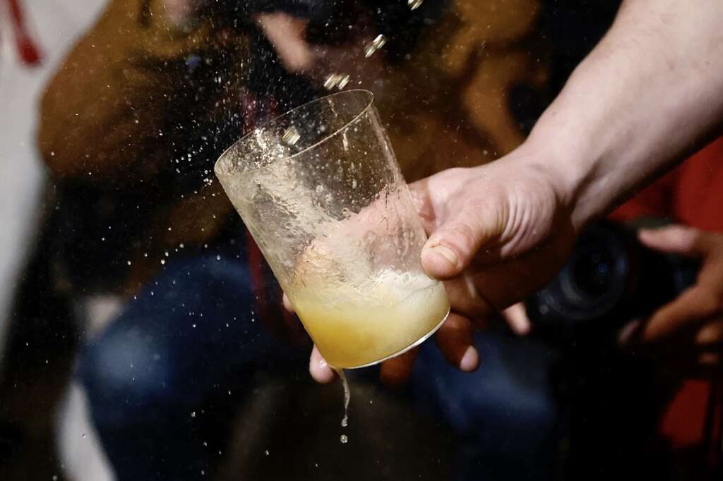Un vaso de sidra que está siendo escanciada