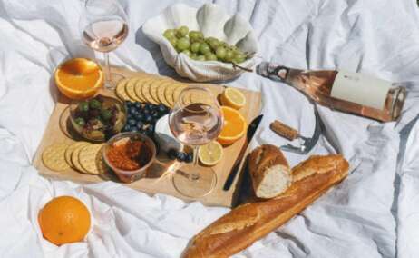 Picnic con copas y botellas de vino, queso y pan