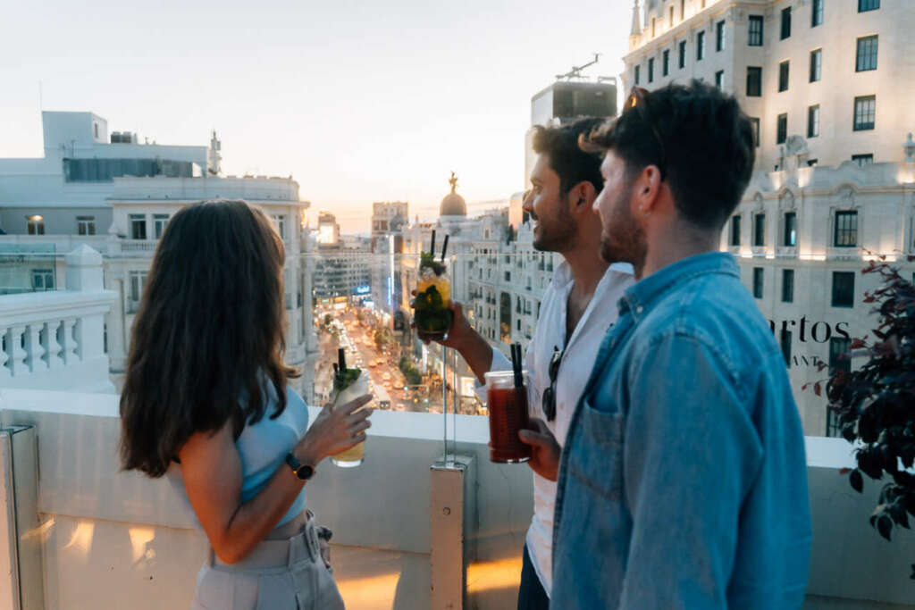Varias personas toman algo con un guía en una azotea, una de las catas de vinos de Madrid