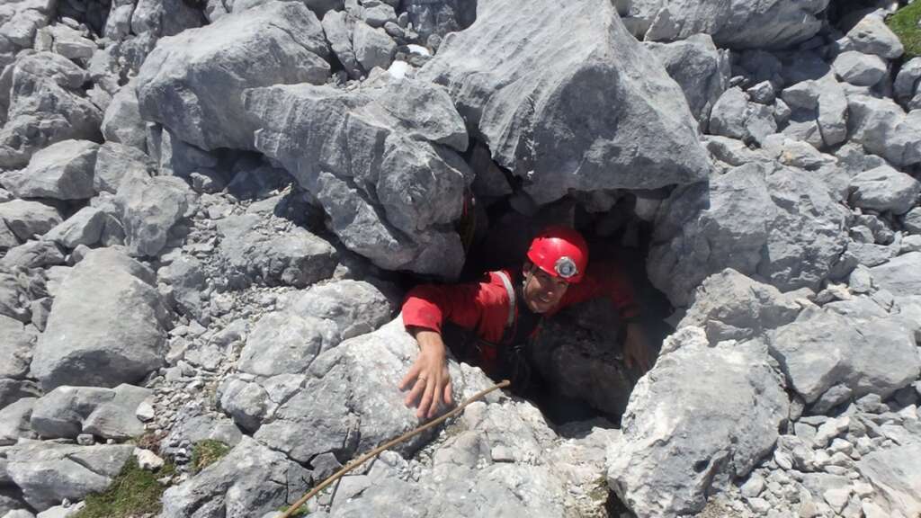 Una persona en una de las entradas de la Torca del Cerro del Cuevón en Asturias