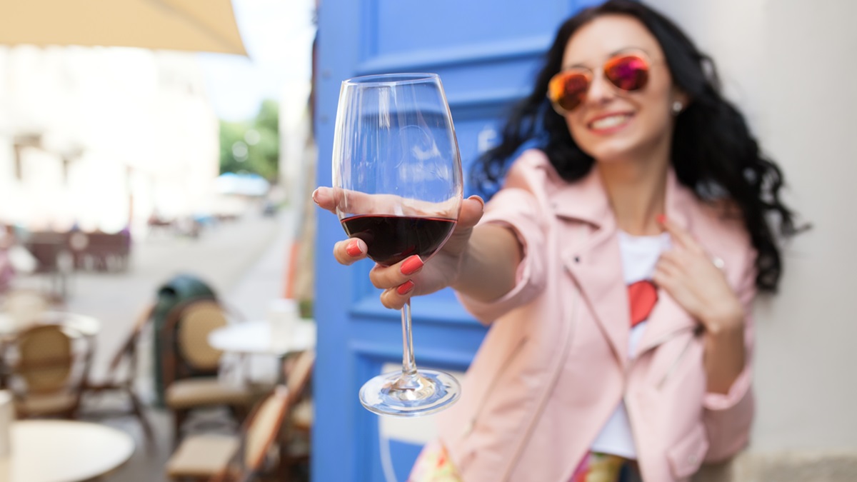 Una chica sostiene una copa de vino tinto