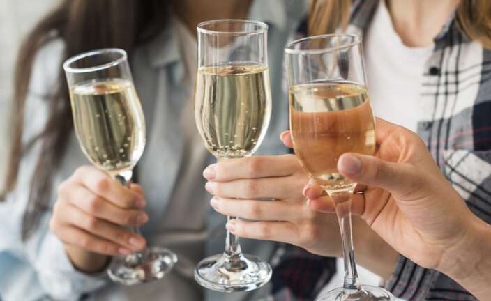 Varias personas brindan con copas de Champagne