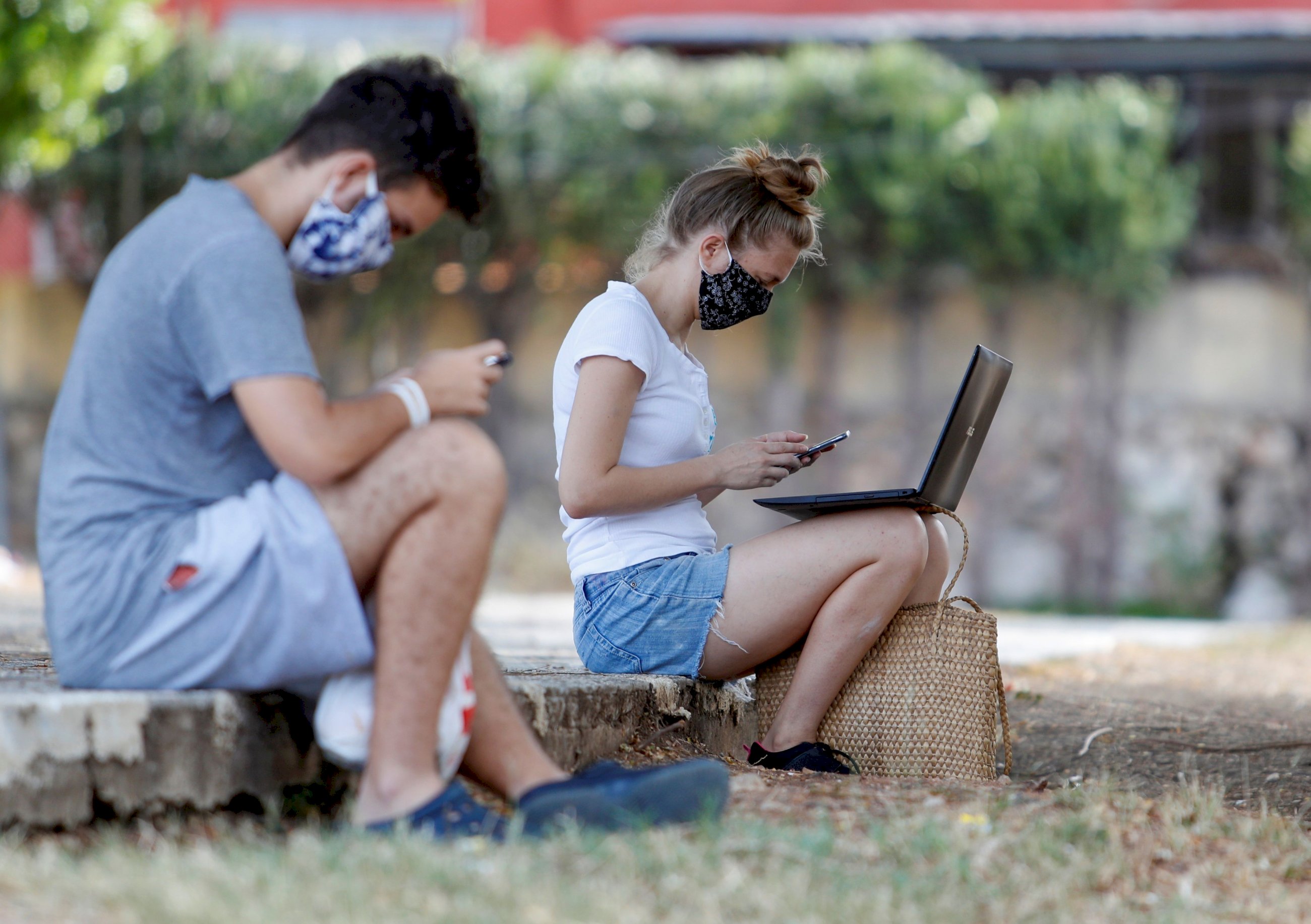 Dos jóvenes conectados a internet desde un parque. Foto: Efe