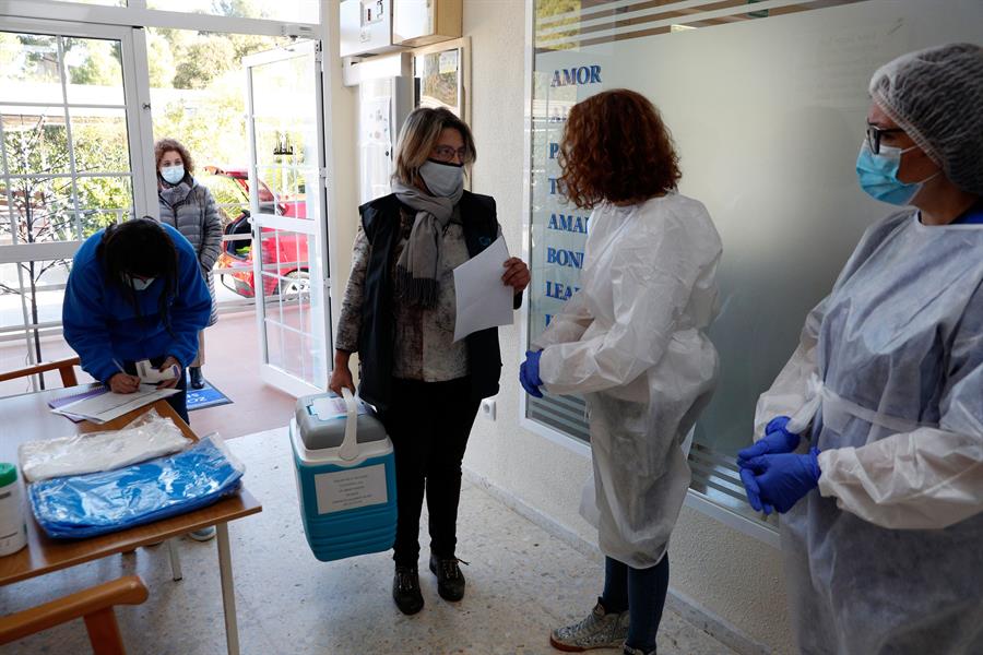 Una trabajadora de la consellería de Sanidad de la generalitat Valenciana, descarga el primer lote de vacunas a su llegada a la residencia Casa Retino El Salvador, en Torrent (Valencia) / EFE