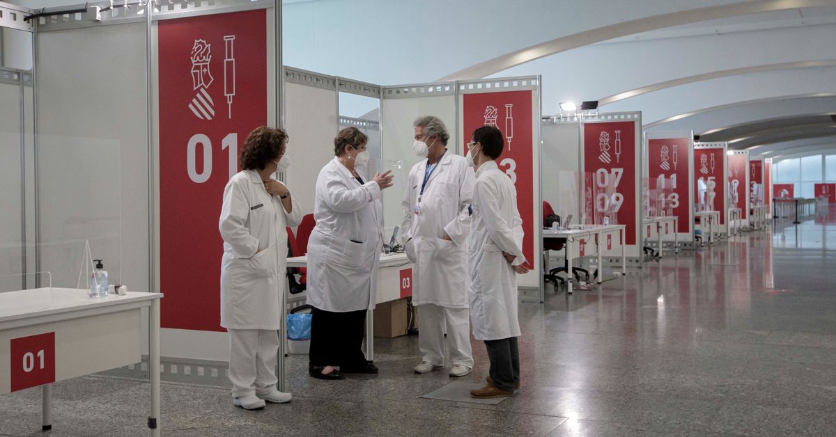Varios sanitarios conversan este sábado en el punto de vacunación masiva de Valencia situado en la Ciudad de las Artes y las Ciencias. EFE/Biel Aliño