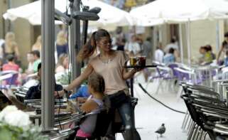 Una camarera sirve una consumición en una terraza. EFE/Javier Etxezarreta
