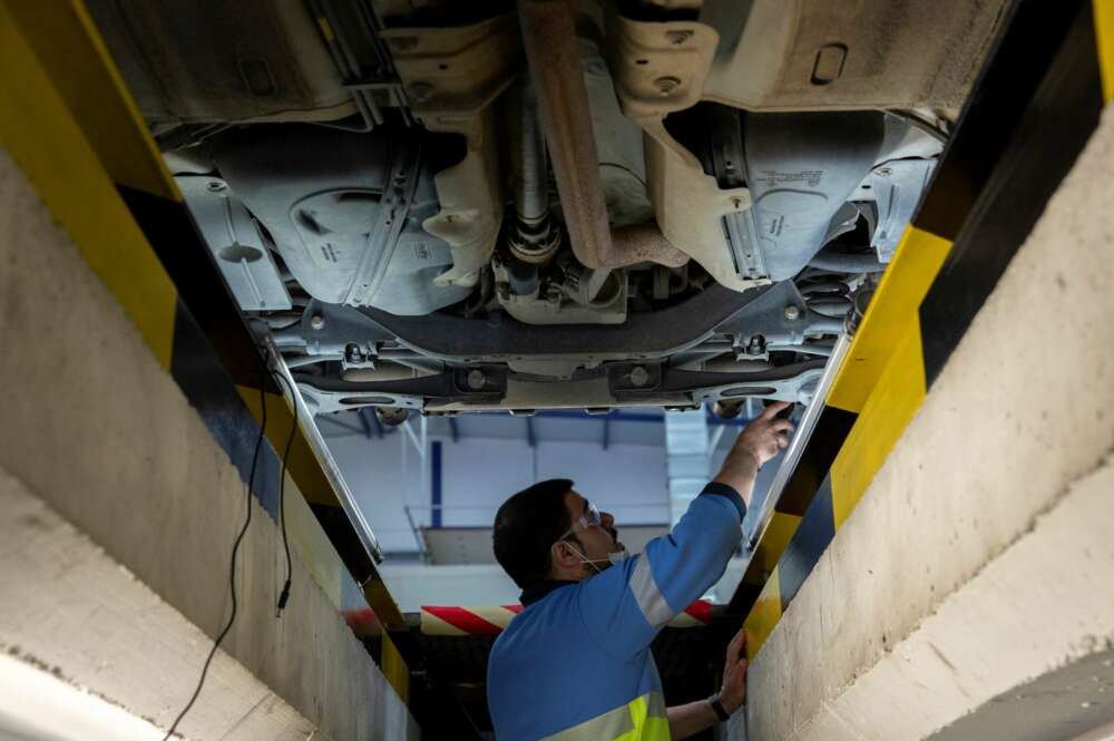 GRAFAND8505. SANLÚCAR LA MAYOR (SEVILLA), 18/05/2020.- Un técnico inspecciona los bajos de un vehículo de la estación de Inspección Técnica de Vehículos ITV de Sanlúcar la Mayor (Sevilla), provincia que se encuentra en el fase 1 de la desescalada en la que está permitido la apertura de estos establecimientos. EFE/Julio Muñoz