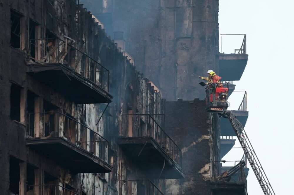 Los bomberos continúan trabajando tras el incendio en un edificio de viviendas de catorce plantas en València. EFE/Biel Aliño