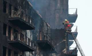 Los bomberos continúan trabajando tras el incendio en un edificio de viviendas de catorce plantas en València. EFE/Biel Aliño