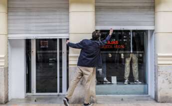 El trabajador de un comercio cierra su establecimiento en Valencia. Foto: Rober Solsona /Europa Press