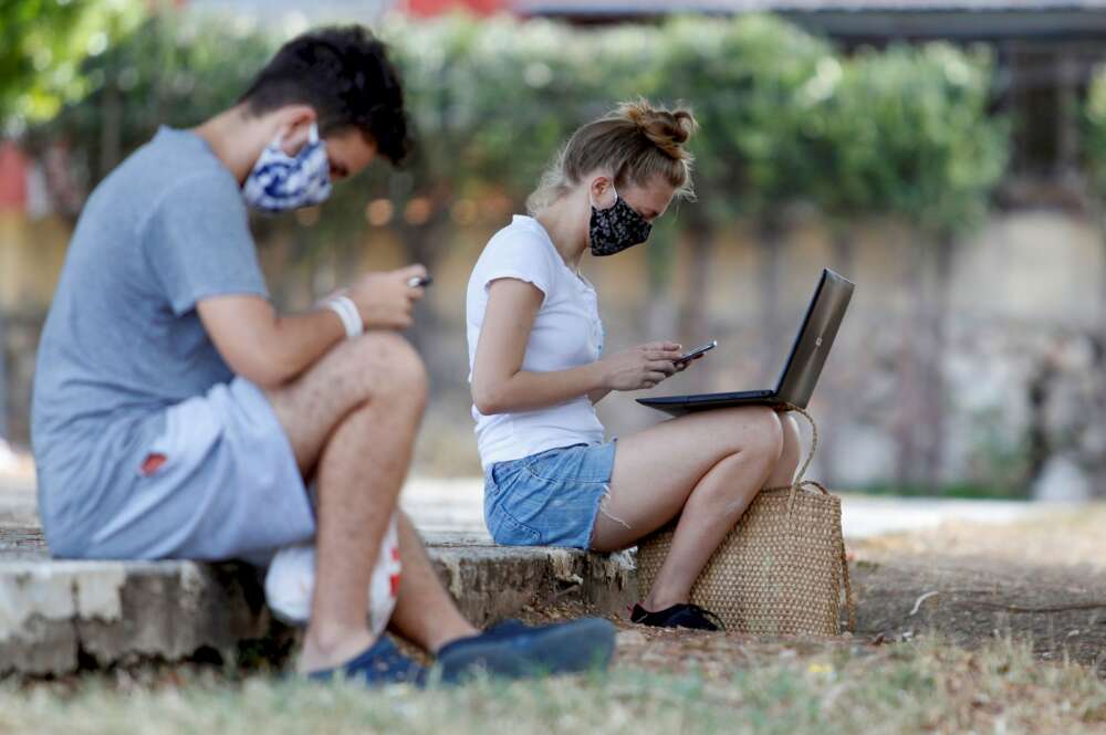 Dos jóvenes conectados a internet desde un parque. Foto: Efe