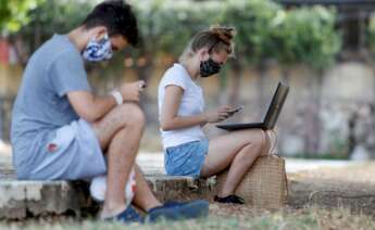 Dos jóvenes conectados a internet desde un parque. Foto: Efe