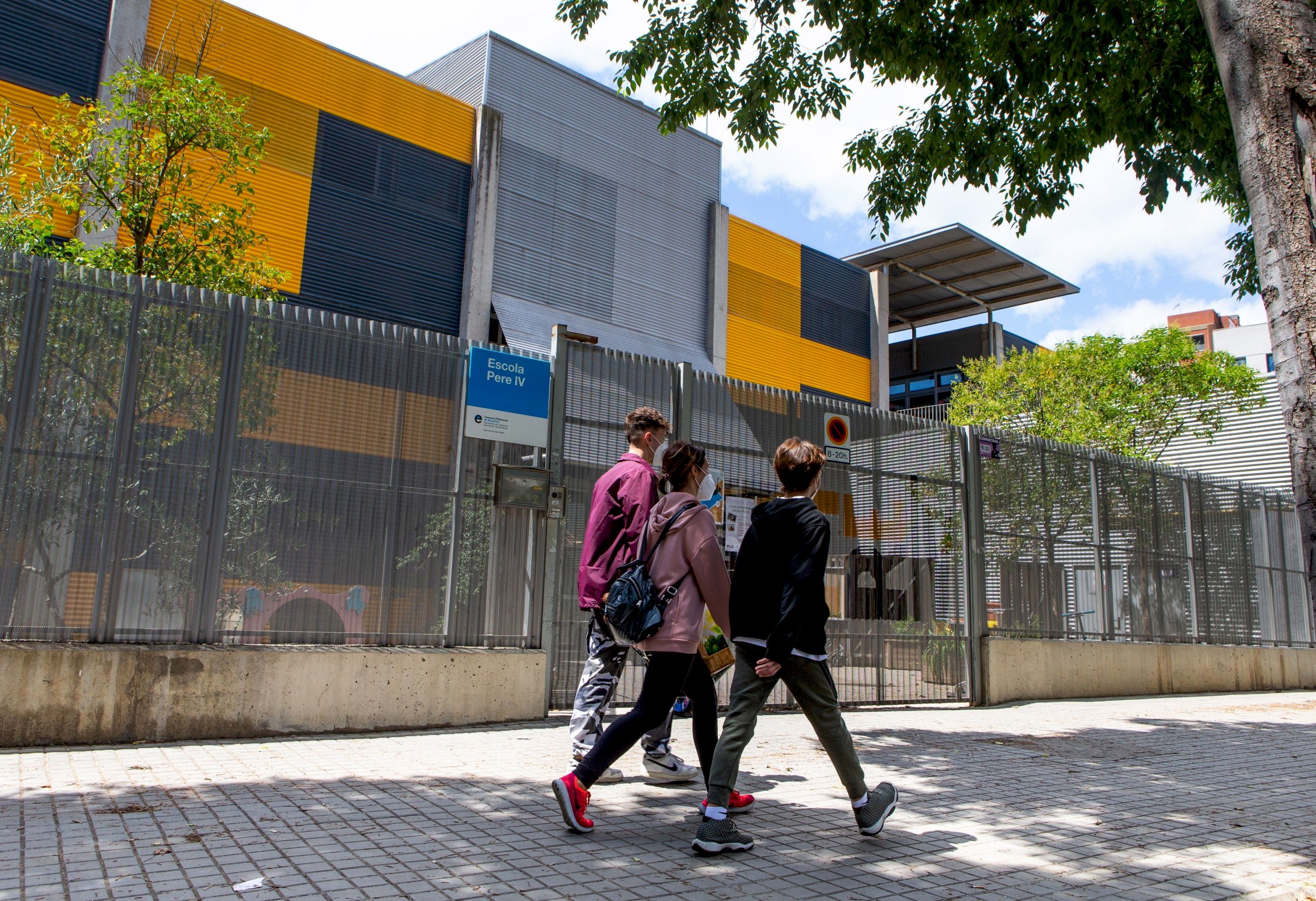 Varios adolescentes pasean frente a una escuela cerrada. Foto: Efe