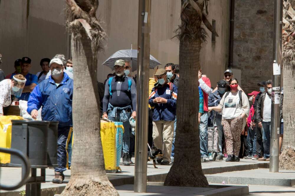 Los ciudadanos forman fila frente al comedor social del barrio del Raval, en Barcelona, durante la crisis del coronavirus EFE/Marta Pérez