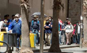 Los ciudadanos forman fila frente al comedor social del barrio del Raval, en Barcelona, durante la crisis del coronavirus EFE/Marta Pérez