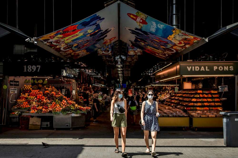 Dos visitantes salen del mercado de la Boquería de Barcelona. Foto: Efe