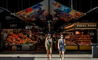 Dos visitantes salen del mercado de la Boquería de Barcelona. Foto: Efe