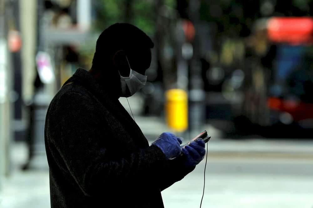 Un hombre usa su teléfono móvil en una calle de Valencia. Foto: Efe/Manuel Bruque/Archivo