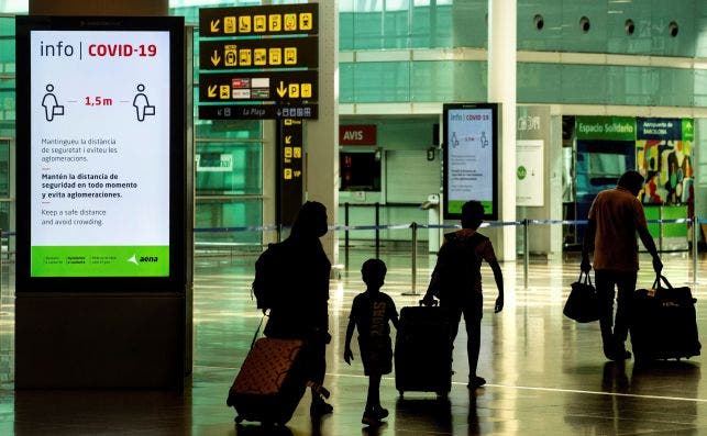 Viajeros con máscaras sanitarias caminan por la Terminal 1 del aeropuerto Josep Tarradelles - El Prat, en Barcelona. Foto: Efe/Enric Fontcuberta