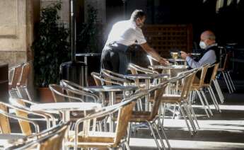 Un camarero atiende a un cliente, este miércoles, en un local de la Plaza Real de Barcelona. /EFE/Quique Garcia