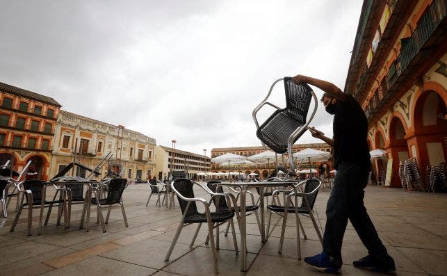 Un trabajador de un bar prepara la terraza en Córdoba el 25 de octubre de 2020. Andalucía sopesa el confinamiento perimetral pero aún no ha tomado la decisión | EFE/Salas/Archivo