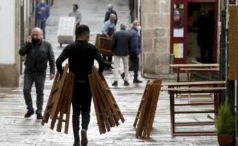 Un camarero monta una terraza en una calle de Santiago de Compostela, uno de los sectores más afectados por la crisis económica en España. EFE/Lavandeira jr