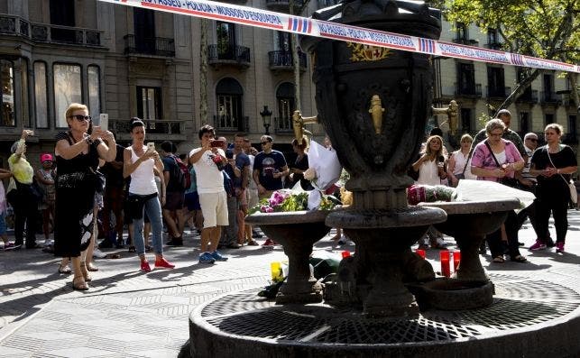 Barcelona: dolor, solidaridad y unidad. Varias personas fotografían la fuente de Canaletas, en las Ramblas de Barcelona, en la que se han depositado velas y flores después del atentado ocurrido este jueves. EFE/Quique Garcia