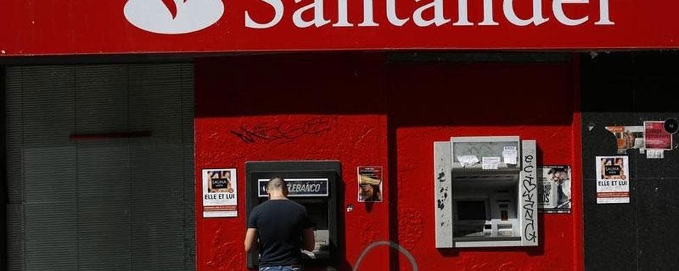 Un cliente saca dinero de un cajero del Banco Santander