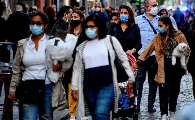 Varios ciudadanos pasean por una calle en Nápoles (Italia) abarrotada de gente, con mascarillas para prevenir la Covid-19 / EFE