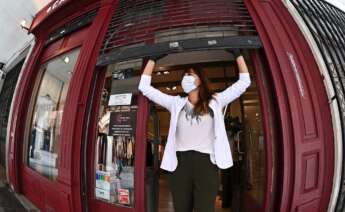 Una mujer abre su negocio. Foto: EFE