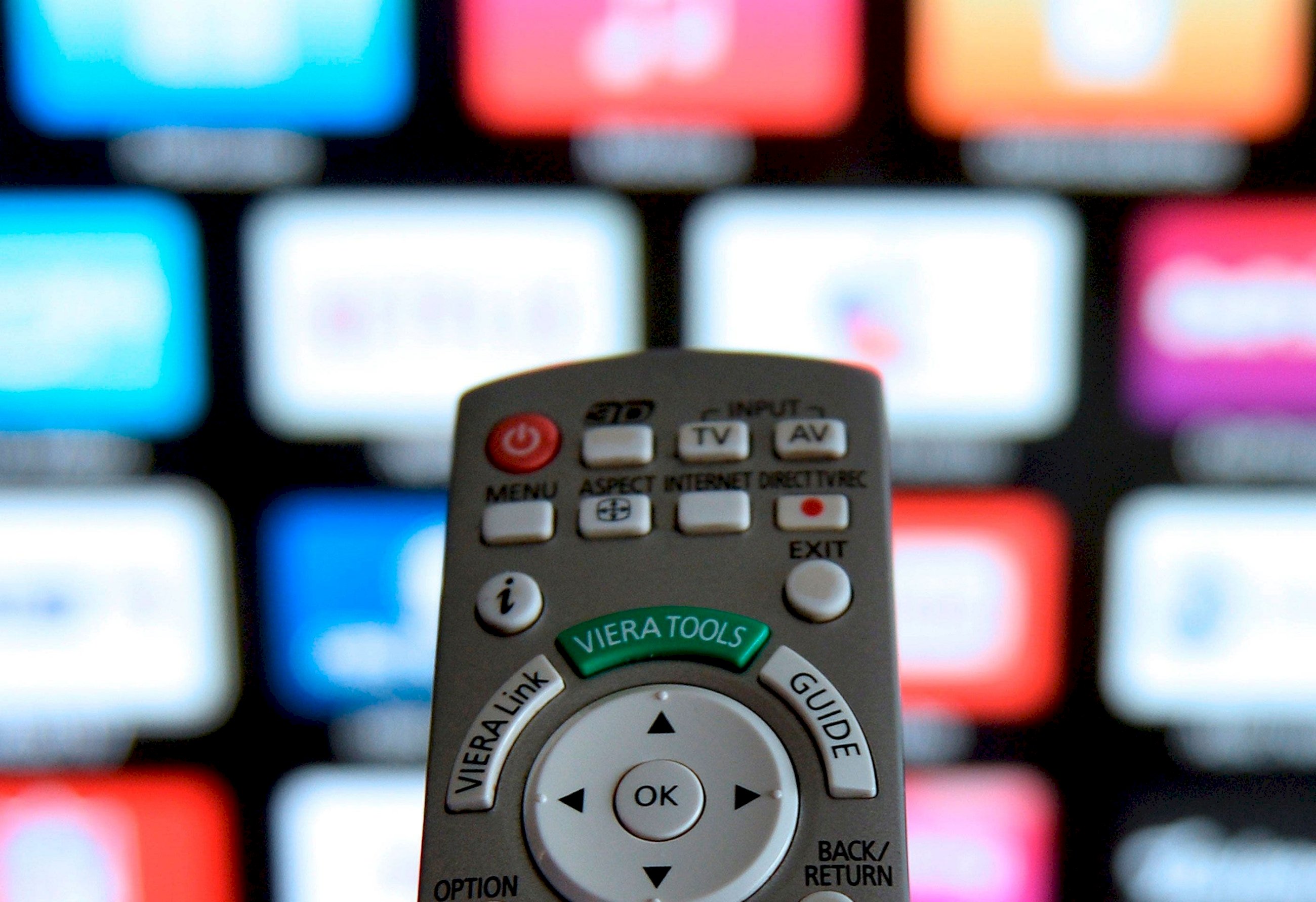 Un mando de televisión frente a una pantalla donde se muestran varias plataformas