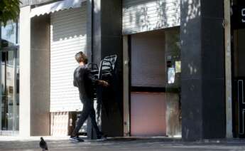 Un camarero recoge las sillas de una terraza de un restaurante del barrio de la Barceloneta de Barcelona. EFE/Quique García