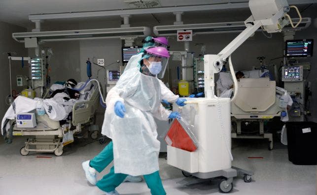 Sanitarios atienden a un paciente en la Unidad de Cuidados Intensivos del Hospital La Fé de Valencia / EFE (Juan Carlos Cárdenas)