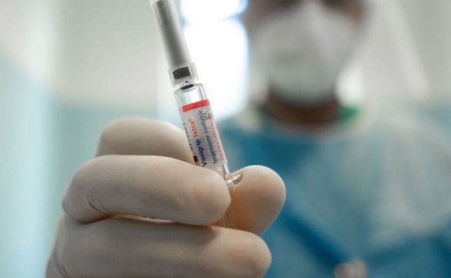 Un médico en Milán (Italia) sostiene una vacuna para la gripe / EFE
