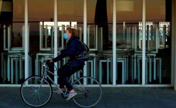 Una mujer pasea en bicicleta con la mascarilla puesta en Barcelona, durante la pandemia de coronavirus de 2020 | EFE/EF/Archivo