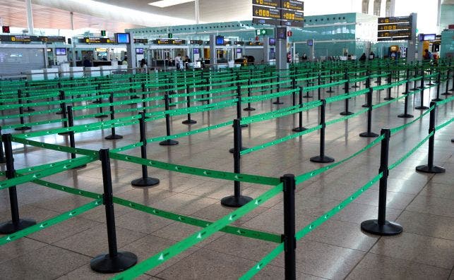Vista de las colas para facturar el equipaje prácticamente vacías en el aeropuerto de El Prat como consecuencia de las restricciones / EFE