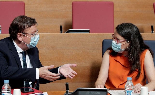 El president de la Generalitat, Ximo Puig, conversa con la vicepresidenta, Mónica Oltra, durante un pleno de Les Corts. Ambos se han enzarzado por sus diferencias en el plan estratégico tras la Covid-19. EFE/Archivo