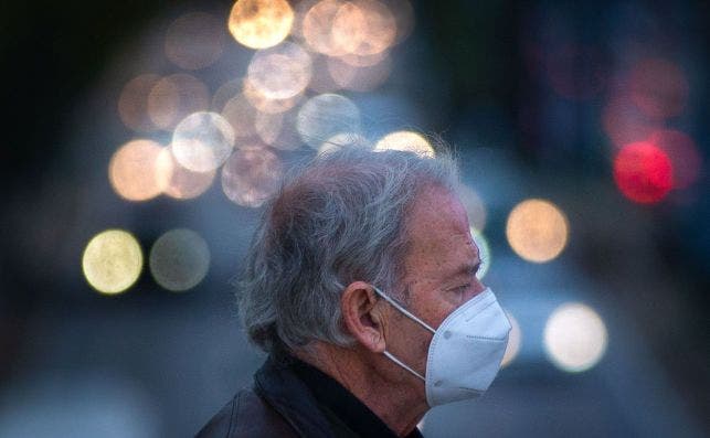 Una persona camina por un puente sobre la Ronda de Dalt de Barcelona con una mascarilla para protegerse de la Covid-19 / EFE