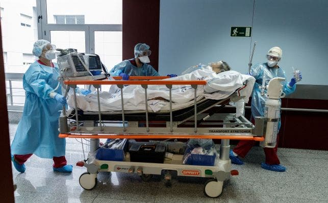 Personal del hospital traslada a Radiología a un paciente con covid-19 desde la UCI del centro sanitario. EFE/Ramón de la Rocha